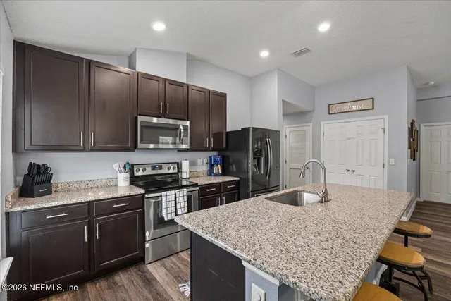 a kitchen with stainless steel appliances granite countertop a sink stove and refrigerator