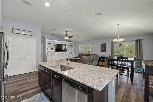a kitchen with stainless steel appliances granite countertop a kitchen island a stove and a dining table with kitchen island