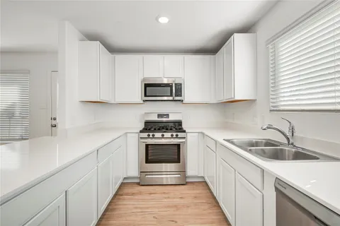 a kitchen with cabinets a sink and a stove top oven