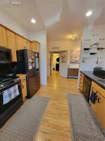 a large kitchen with stainless steel appliances granite countertop a refrigerator and stove