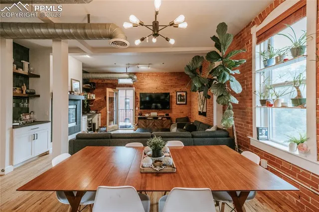 a view of a dining room with furniture a chandelier and wooden floor