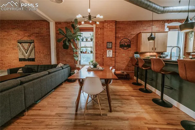 a living room with couches a dining table and chairs with wooden floor