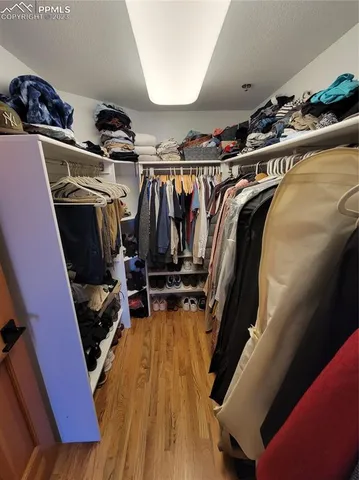 a view of walk in closet with clothes and shoes