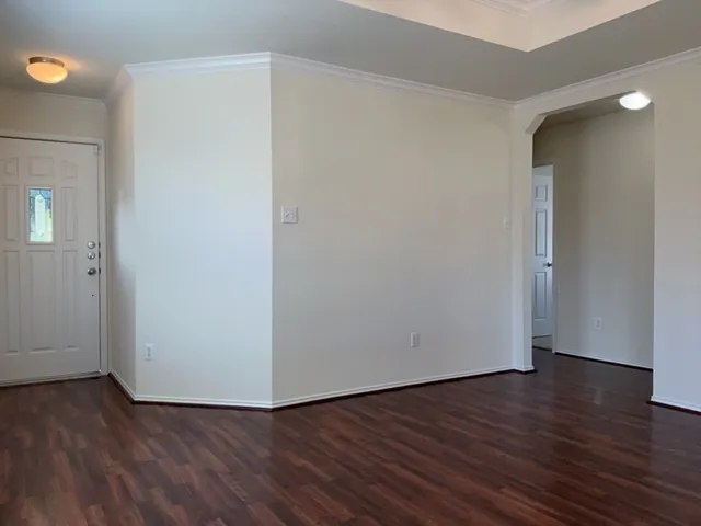 a view of an empty room with wooden floor and closet