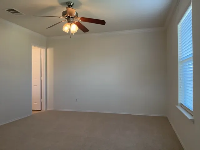 an empty room with windows and fan