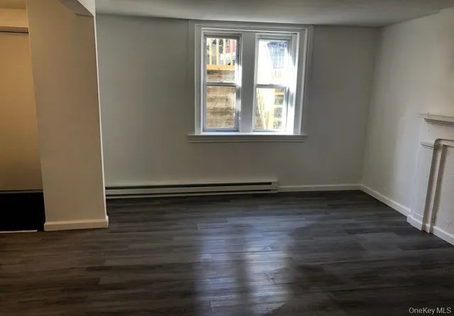 a view of a room with wooden floors and window