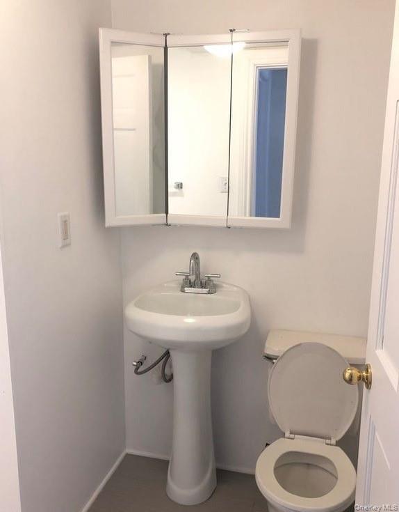 69 Lander Street Newburgh, NY 12550 - Photo 4 of 6 a bathroom with a sink toilet and a mirror