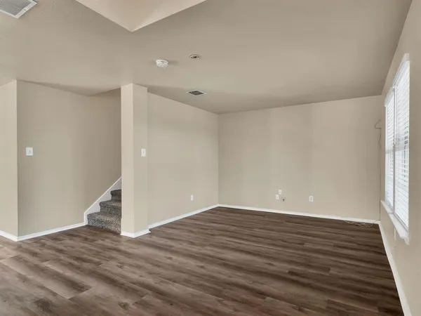 wooden floor in an empty room with a window