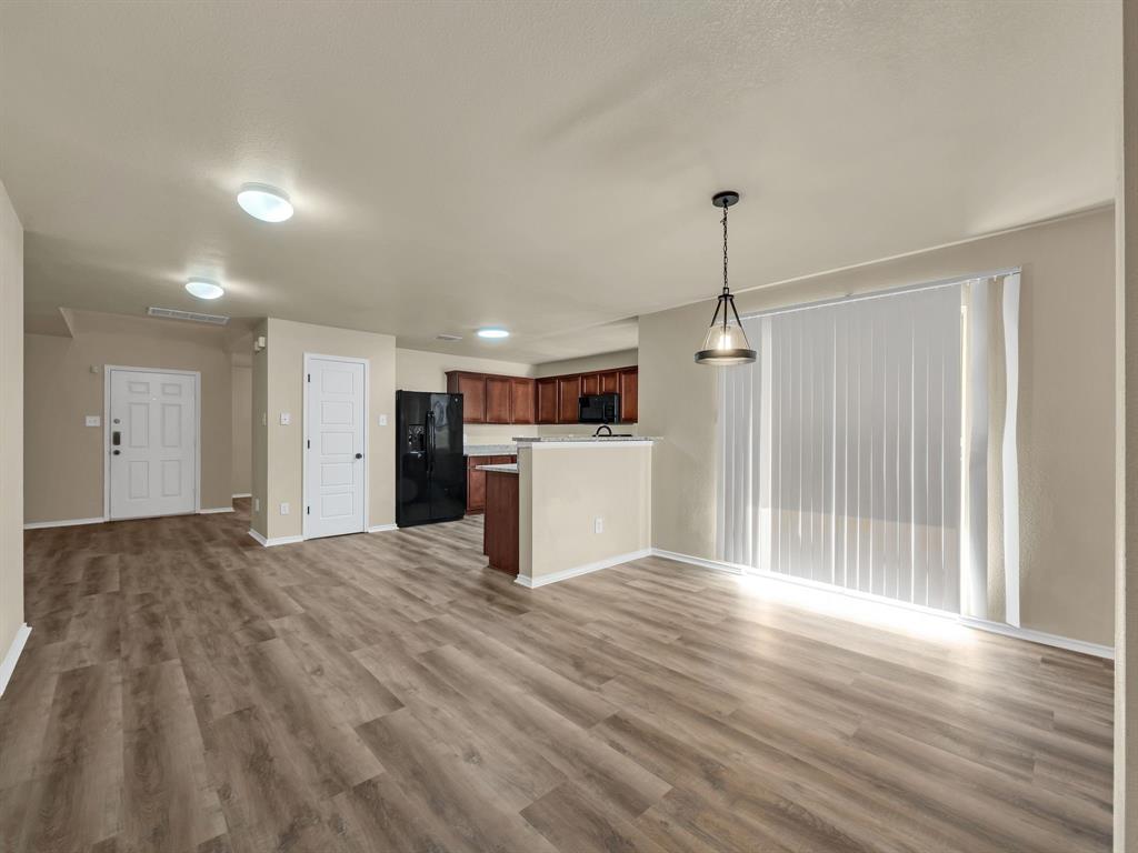 2917 Mayfair Lane Lancaster, TX 75134 - Photo 15 of 40 Unfurnished living room featuring light wood finished floors and baseboards