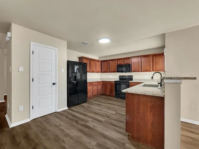 a kitchen with stainless steel appliances granite countertop a refrigerator and a sink