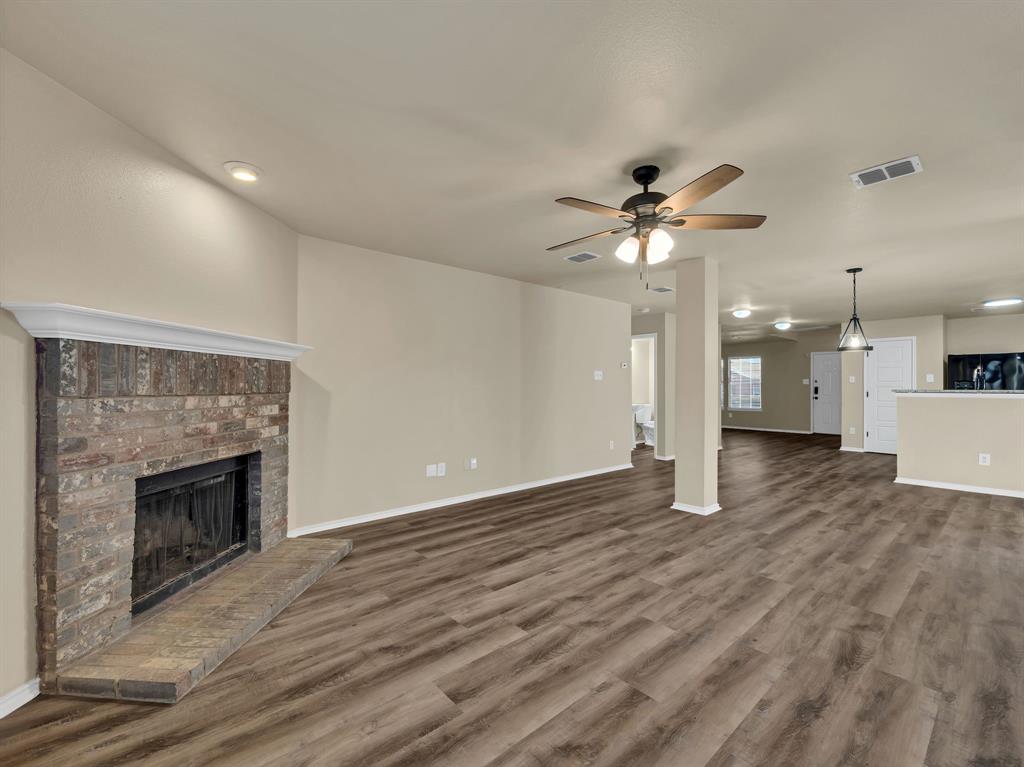 2917 Mayfair Lane Lancaster, TX 75134 - Photo 18 of 40 Unfurnished living room with a brick fireplace, dark wood finished floors, and ceiling fan