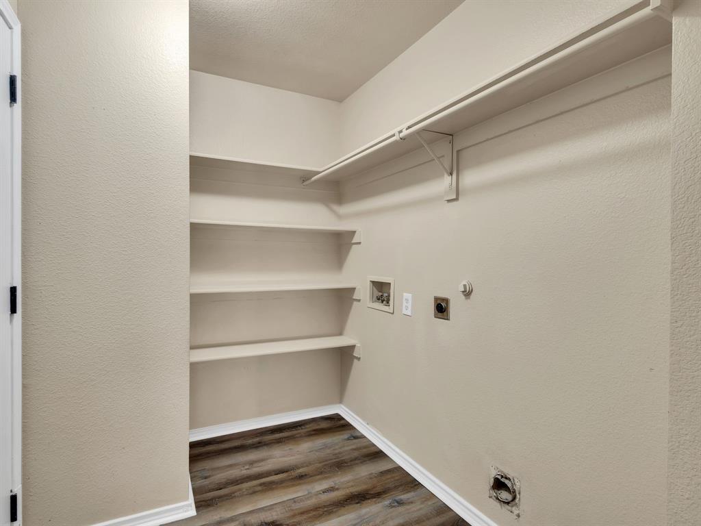 2917 Mayfair Lane Lancaster, TX 75134 - Photo 19 of 40 Laundry room with gas dryer hookup, dark wood-type flooring, washer hookup, hookup for an electric dryer, and a textured wall