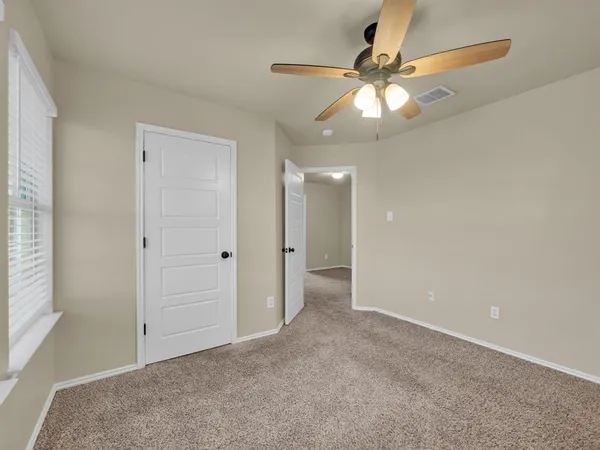 an empty room with fan and entrance
