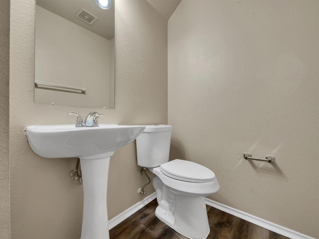 2917 Mayfair Lane Lancaster, TX 75134 - Photo 34 of 40 Half bath featuring a textured wall and dark wood-style floors