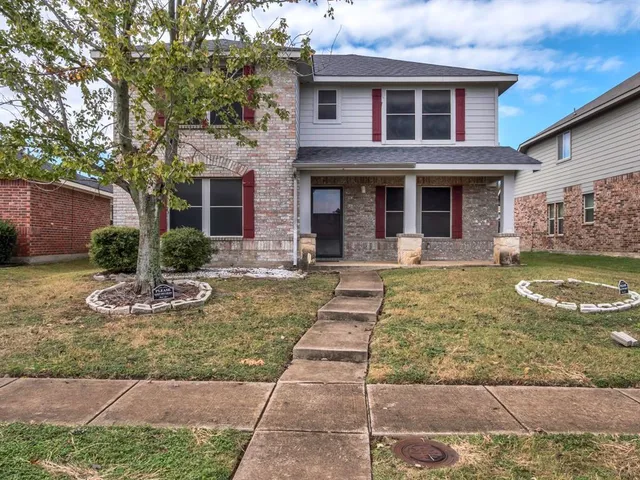 a front view of a house with yard garage and outdoor seating