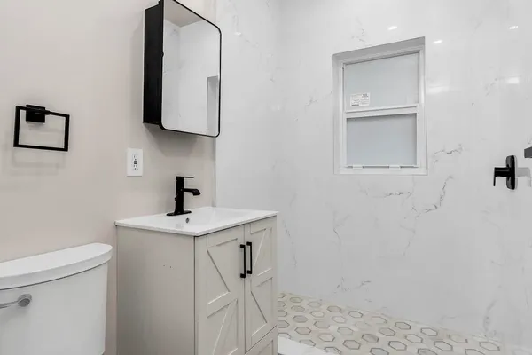 a bathroom with a sink a toilet and mirror