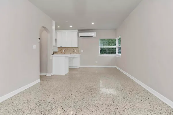 an empty room with a kitchen and a window