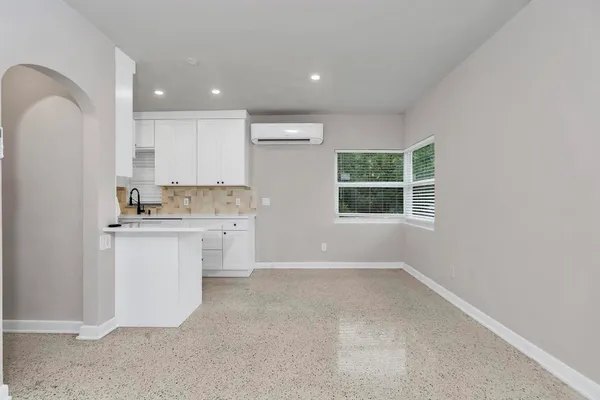 a kitchen with white cabinets and window