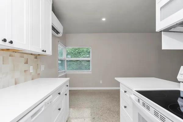 a view of a kitchen with white cabinets