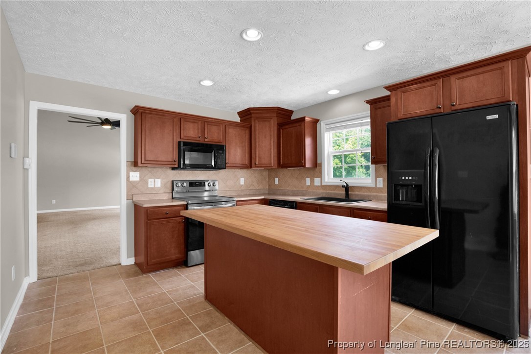 995 Adcox Road Raeford, NC 28376 - Photo 19 of 50 a kitchen with stainless steel appliances granite countertop a refrigerator a sink a stove a microwave and island