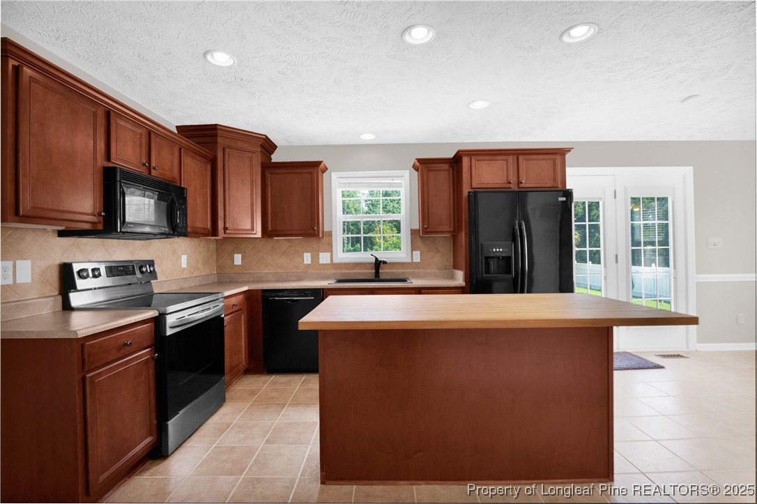 995 Adcox Road Raeford, NC 28376 - Photo 21 of 50 a kitchen with stainless steel appliances granite countertop a refrigerator a stove top oven a sink and dishwasher