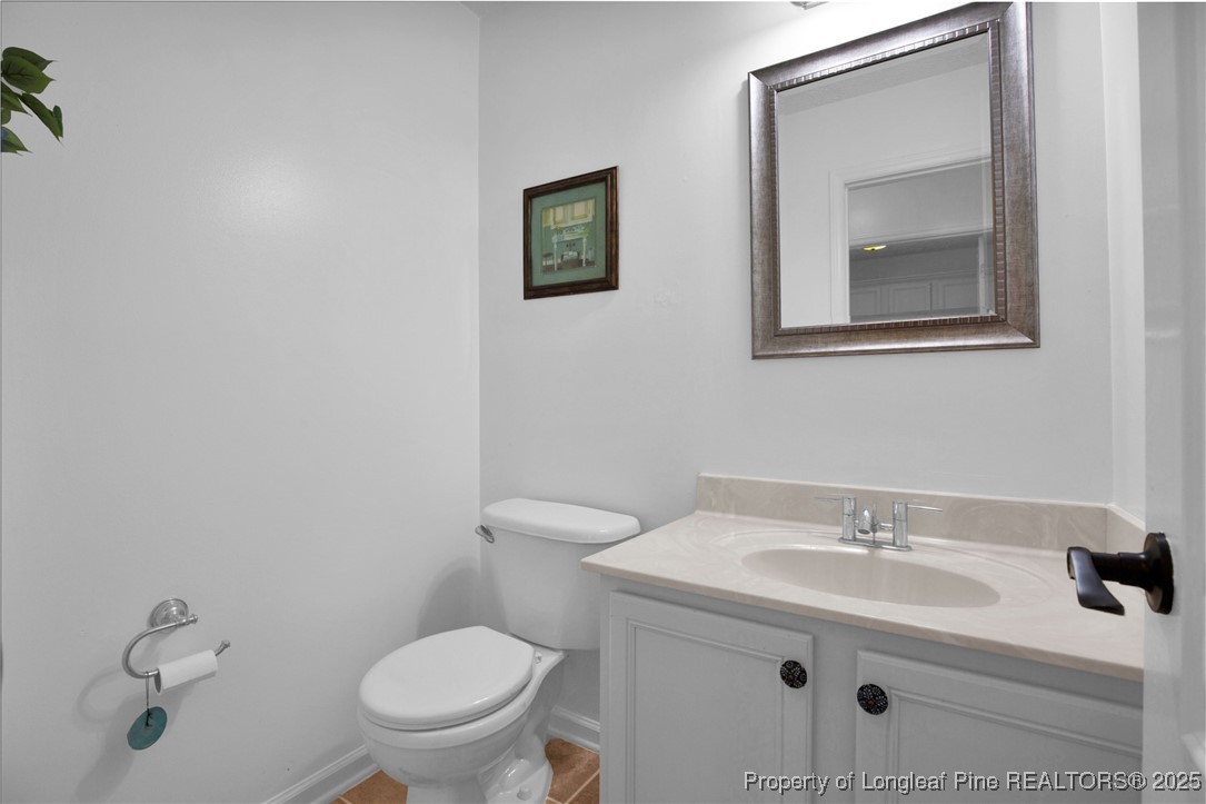 995 Adcox Road Raeford, NC 28376 - Photo 24 of 50 a bathroom with a toilet sink vanity and mirror