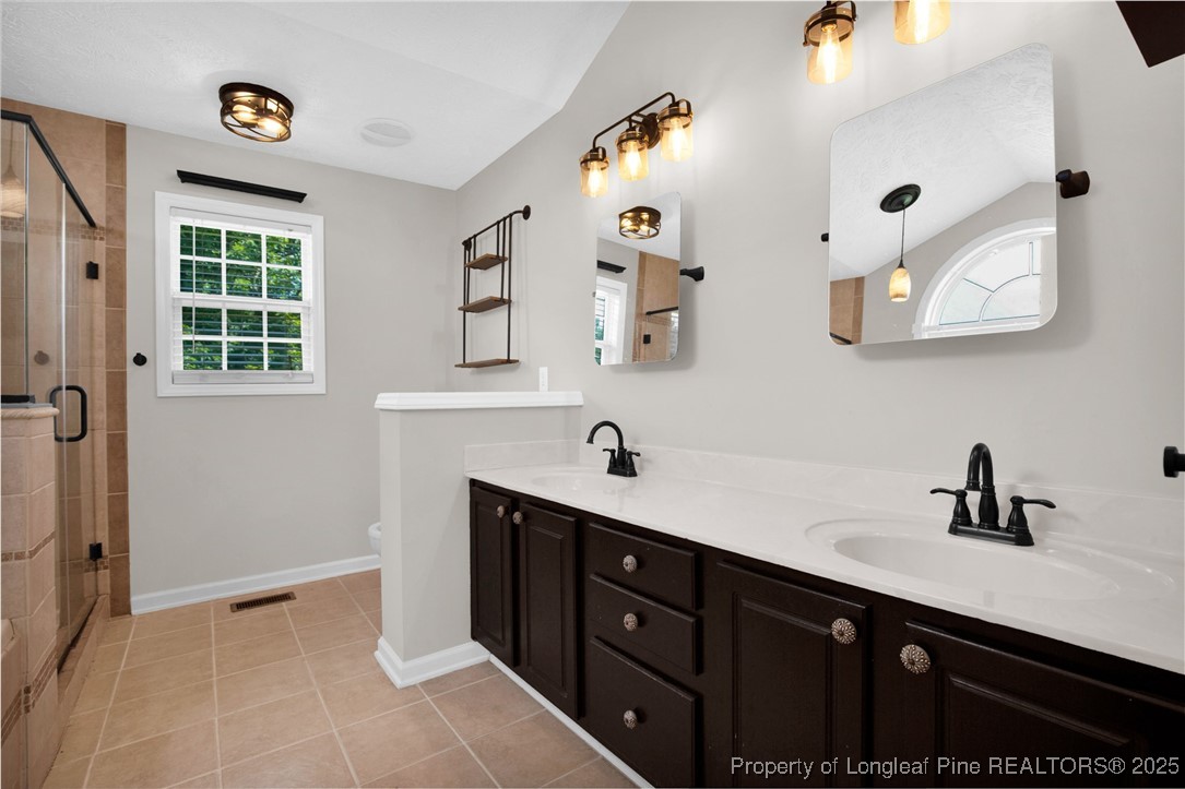 995 Adcox Road Raeford, NC 28376 - Photo 28 of 50 a spacious bathroom with a double vanity sink a mirror and a bathtub