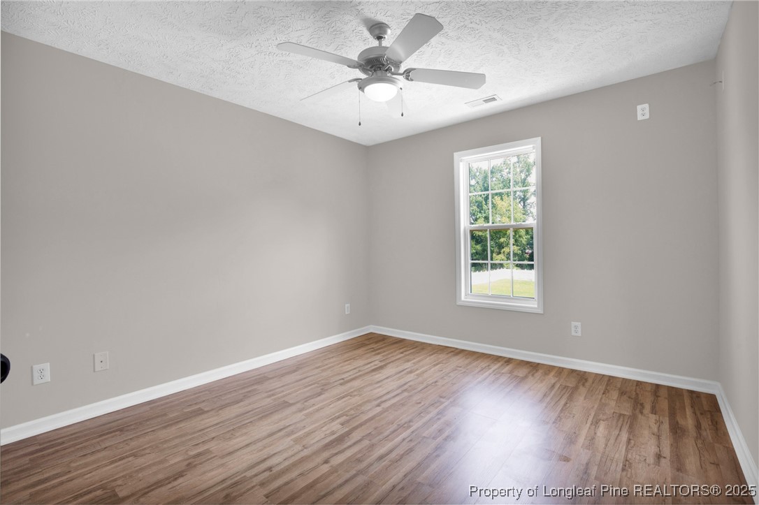995 Adcox Road Raeford, NC 28376 - Photo 36 of 50 an empty room with wooden floor and windows