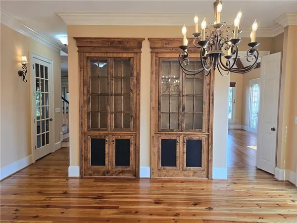 a kitchen with stainless steel appliances granite countertop a refrigerator a stove a sink and white cabinets with wooden floor