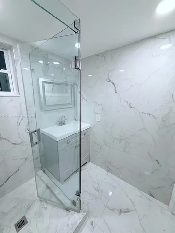 a bathroom with a sink a mirror and shower