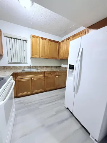 a kitchen with stainless steel appliances granite countertop a refrigerator a sink a stove and island