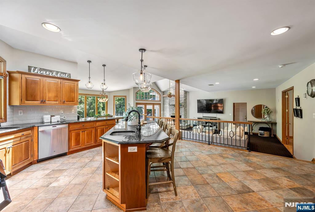 411 Snyder Road Wyckoff, NJ 07481 - Photo 11 of 36 a kitchen with stainless steel appliances kitchen island granite countertop a sink a stove a dining table and chairs
