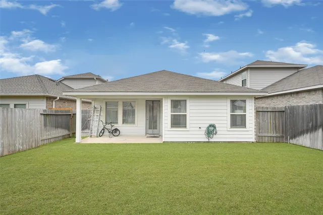 a front view of a house with a garden and chairs