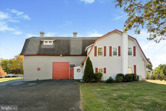 a view of a white house with a yard and a large tree