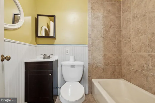 a kitchen with stainless steel appliances kitchen island granite countertop a stove a sink a refrigerator a dining table and chairs with wooden floor