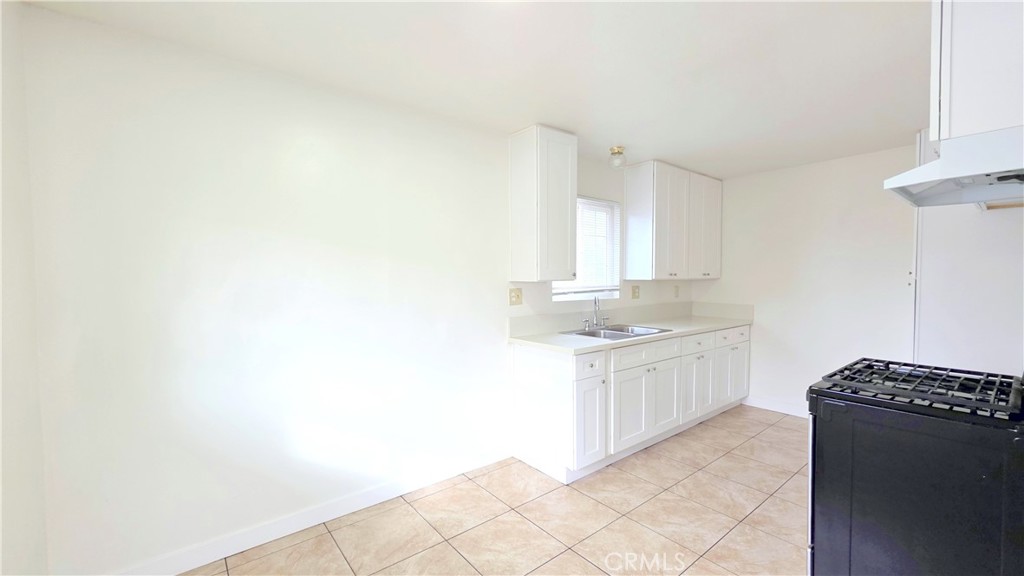 2325 Angela Street, Unit 4 Pomona, CA 91766 - Photo 12 of 21 a kitchen with granite countertop white cabinets and white appliances