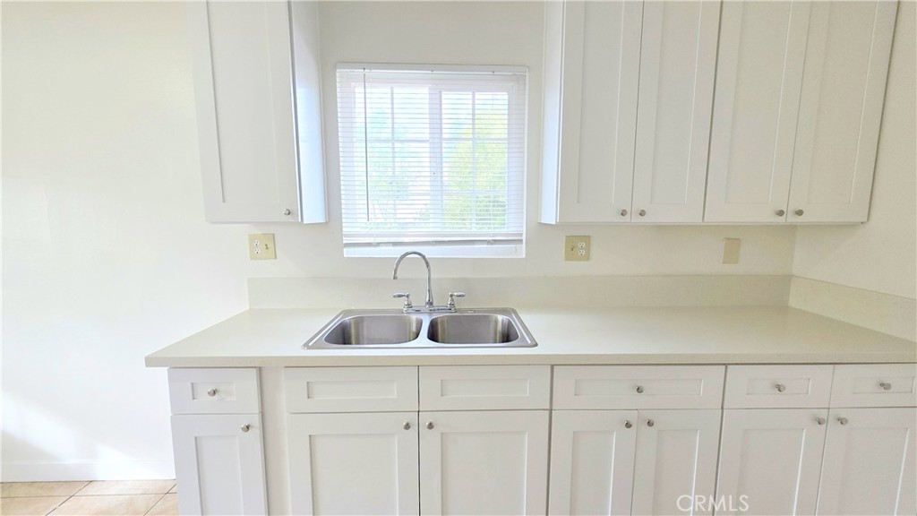 2325 Angela Street, Unit 4 Pomona, CA 91766 - Photo 16 of 21 a kitchen with white cabinets a sink and dishwasher