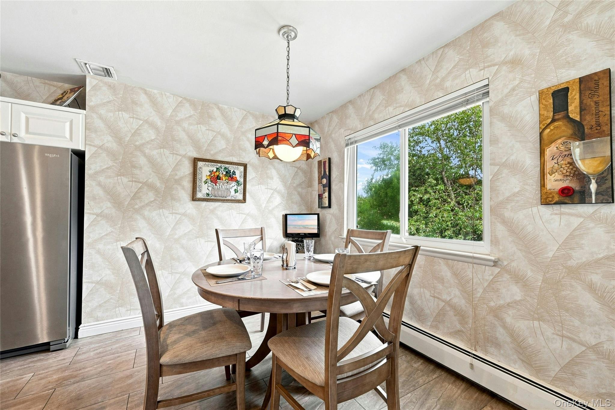3165 Clubhouse Road Merrick, NY 11566 - Photo 22 of 45 Eat in area of the kitchen featuring a decorative ceiling light fixture, wood-finish flooring, and a large window