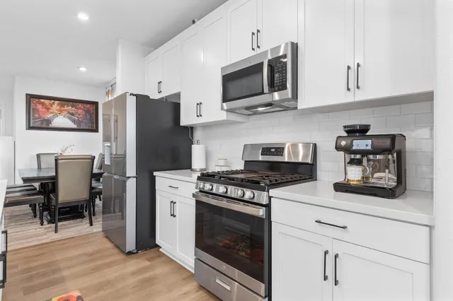 a kitchen with stainless steel appliances a stove microwave and refrigerator