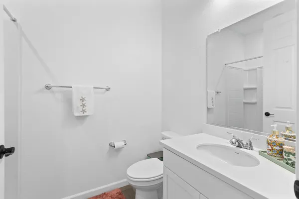 a bathroom with a granite countertop sink a toilet and a mirror