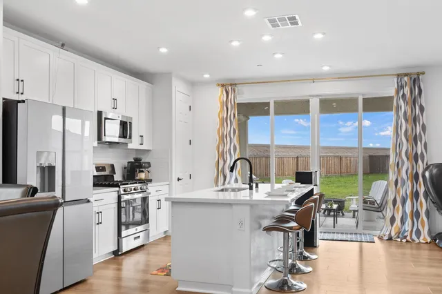 a kitchen with stainless steel appliances kitchen island granite countertop a stove and a sink