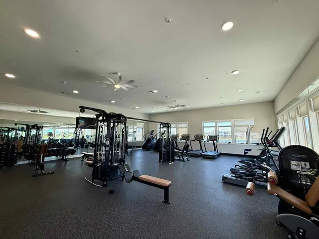 a view of a room with gym equipment and lots of equipment