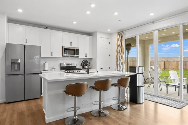 a kitchen with stainless steel appliances granite countertop a stove a sink a refrigerator and a microwave