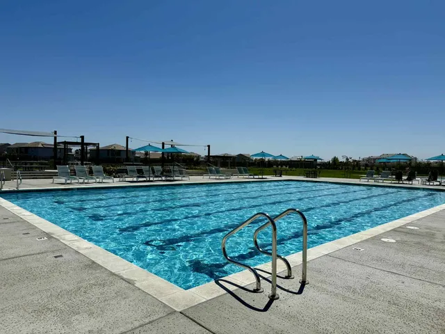 a view of swimming pool with outdoor seating and yard in back