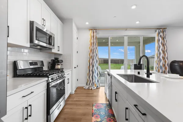 a kitchen with stainless steel appliances granite countertop a sink stove and refrigerator