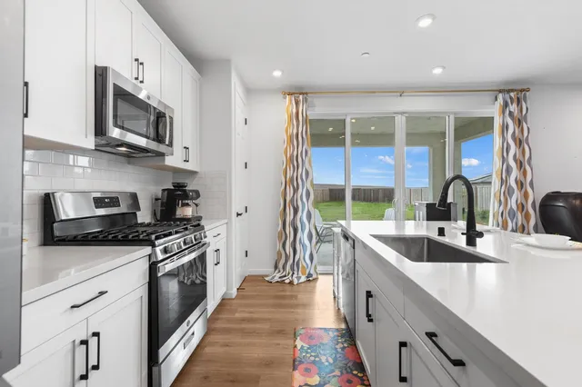 a kitchen with stainless steel appliances granite countertop a sink stove and refrigerator