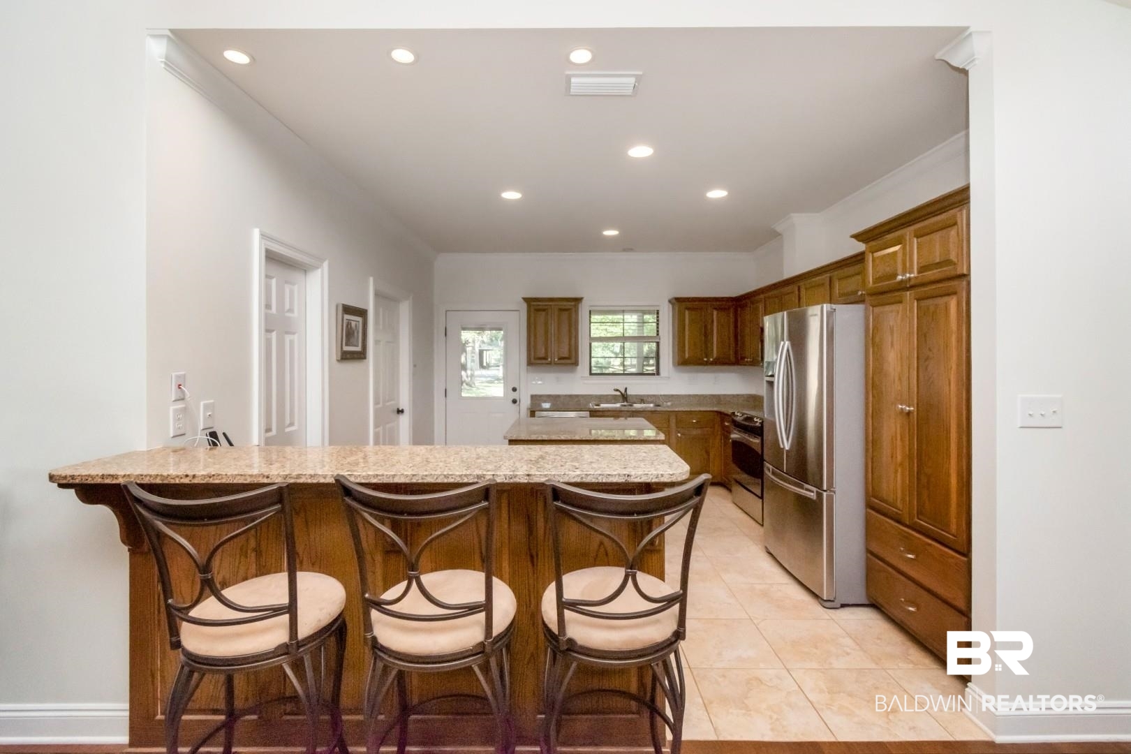 1360 Dykes Road North Mobile, AL 36608 - Photo 13 of 40 Kitchen featuring a breakfast bar, a peninsula, stainless steel appliances, brown cabinets, and recessed lighting