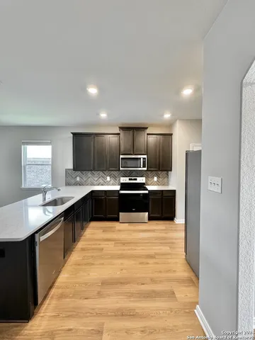 a large kitchen with a large counter top appliances and cabinets