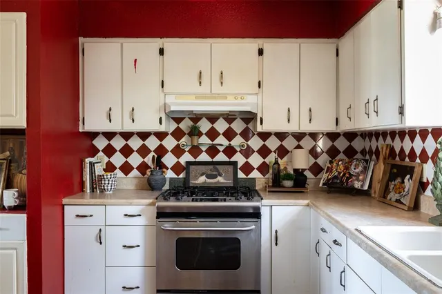 a kitchen with a stove and white cabinets