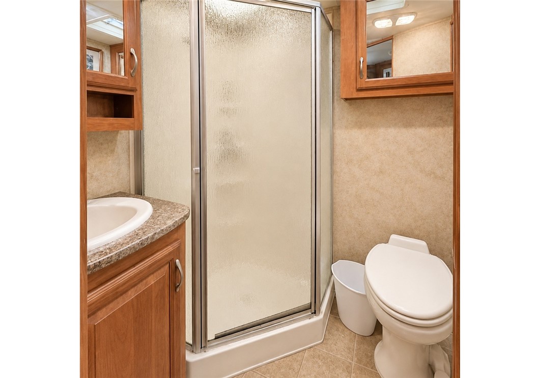 208 Reston Way Westminster, SC 29693 - Photo 7 of 26 This compact bathroom features a corner sink vanity and an enclosed shower, optimizing space efficiently.